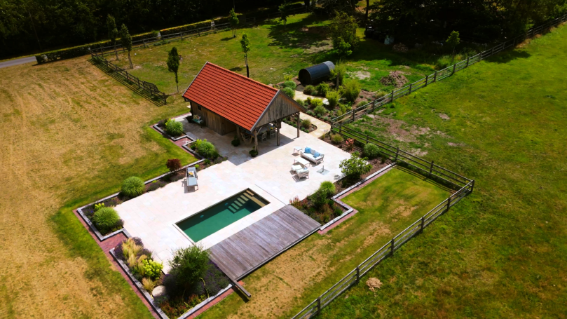 Luftaufnahme eines Ferienhauses mit Pool und Garten in ländlicher Umgebung.