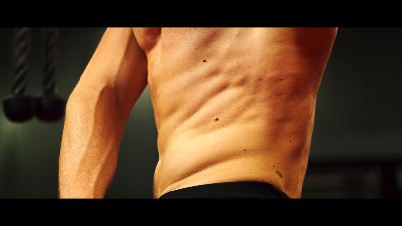 Muskulöser Oberkörper eines trainierten Mannes, mit sichtbaren Bauchmuskeln.